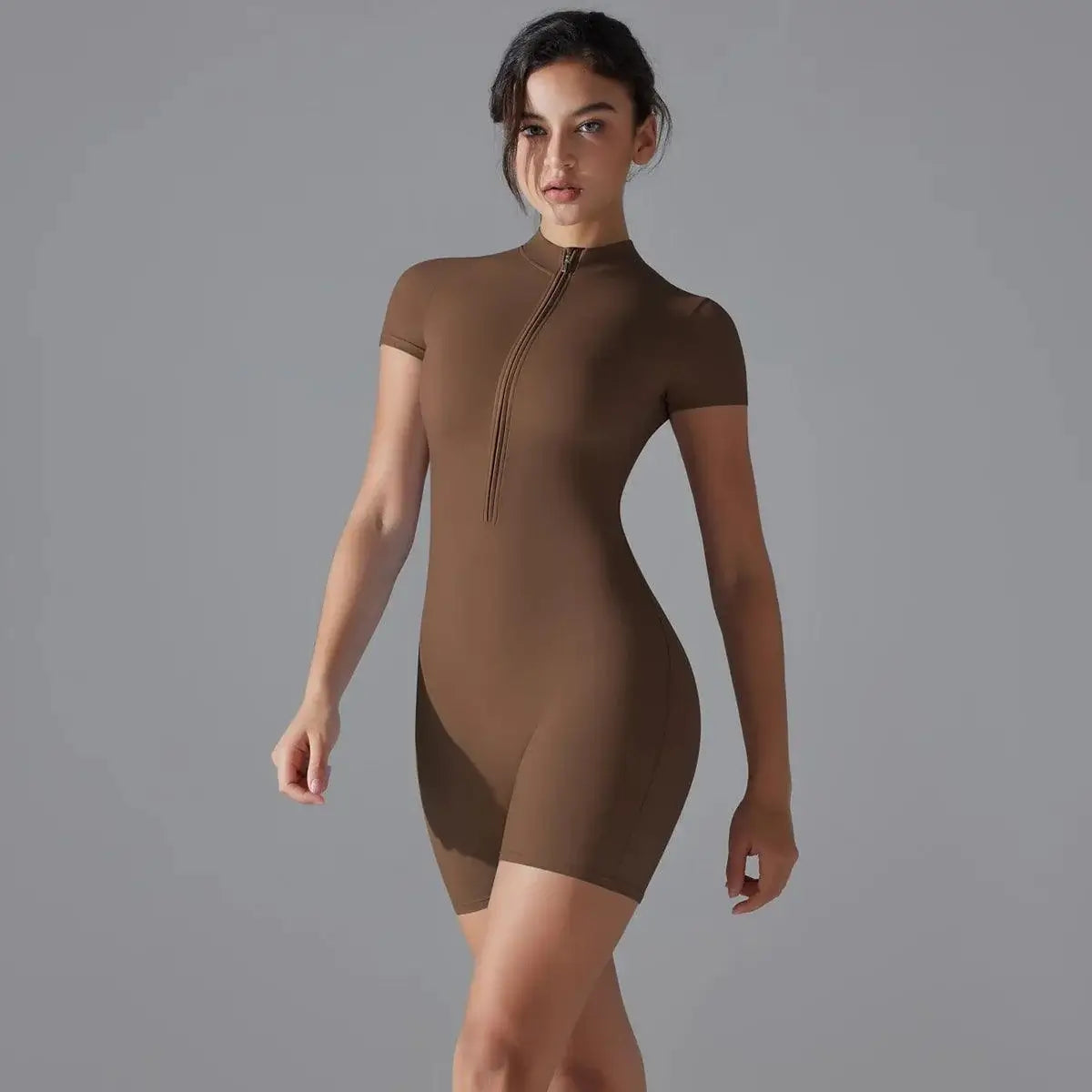 Model wearing a brown VivaSculpt FitOne Suit, featuring a zip closure and slim fit, showcasing high-stretch nylon fabric.
